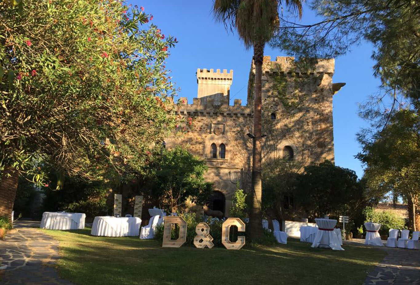 Castillo de las Seguras desde fuera con cocktel preparado e iniciales de los novios en madera